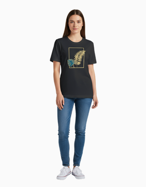 Person wearing a black t-shirt with a golden leaf frame and blue jeans on a white background